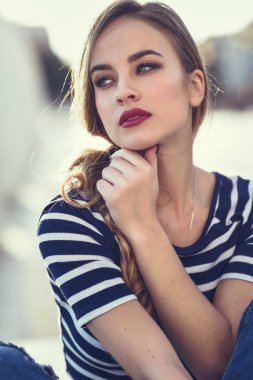 Sarışın kadın, moda, kentsel arka planda oturan modeli.
