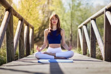 Doğada yoga yaparken genç güzel kadın