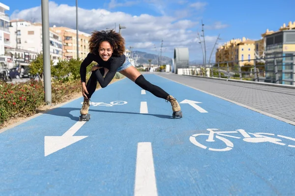 Mujer negra en patines de ruedas montando al aire libre en la calle urbana —  Fotos de Stock