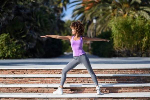 Mujer negra, peinado afro, haciendo yoga en pose guerrera —  Fotos de Stock