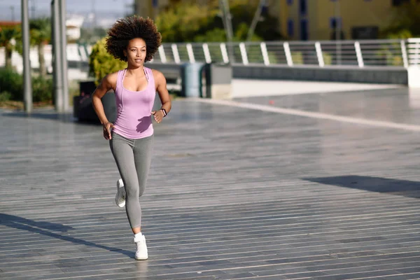 Mujer negra, peinado afro, corriendo al aire libre en carretera urbana . —  Fotos de Stock