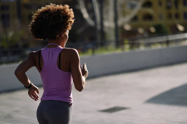 Femme noire, coiffure afro, courant à l'extérieur au coucher du soleil — Photo