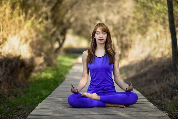 Wanita cantik muda melakukan yoga di alam — Stok Foto