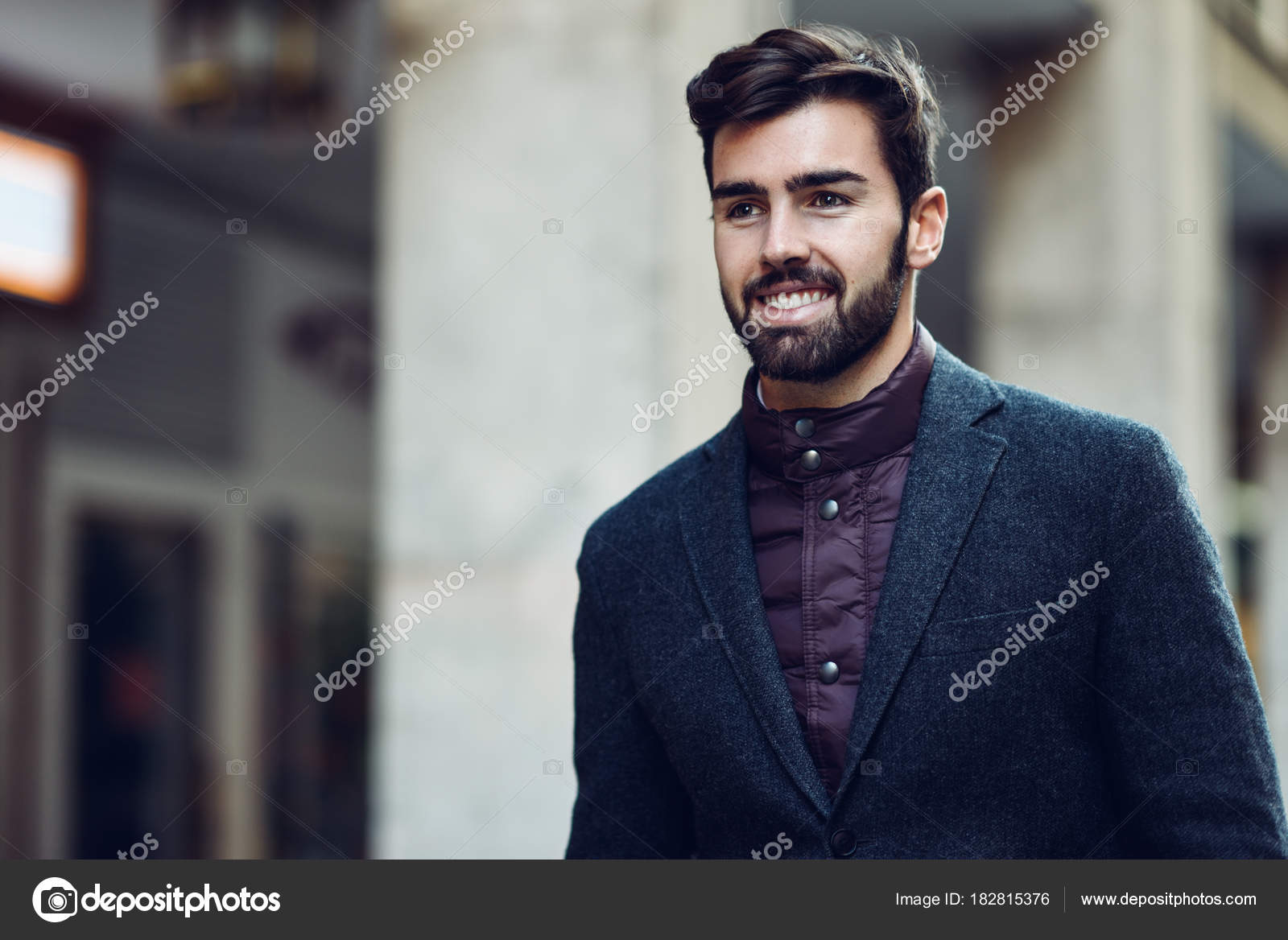 Young bearded smiling man wearing british elegant suit in the st