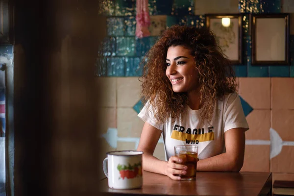 Arabische vrouw in een prachtige bar op zoek door het raam — Stockfoto