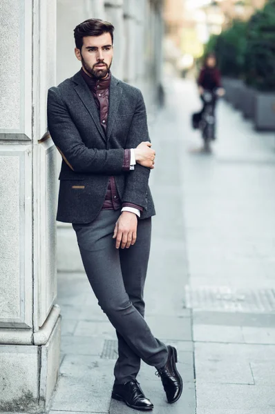 Giovane uomo barbuto in background urbano indossa britannico elegante su — Foto Stock