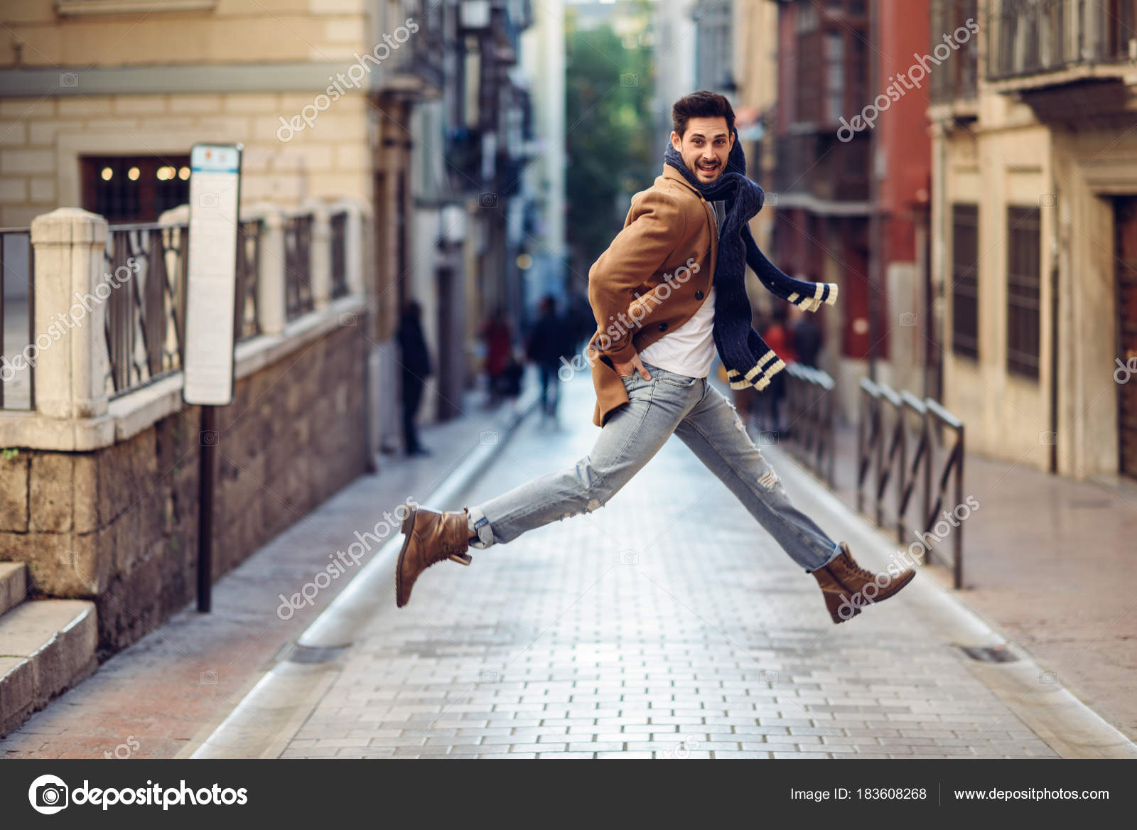 Joven hombre feliz saltando con ropa de en urbano: fotografía stock © javiindy #183608268 | Depositphotos