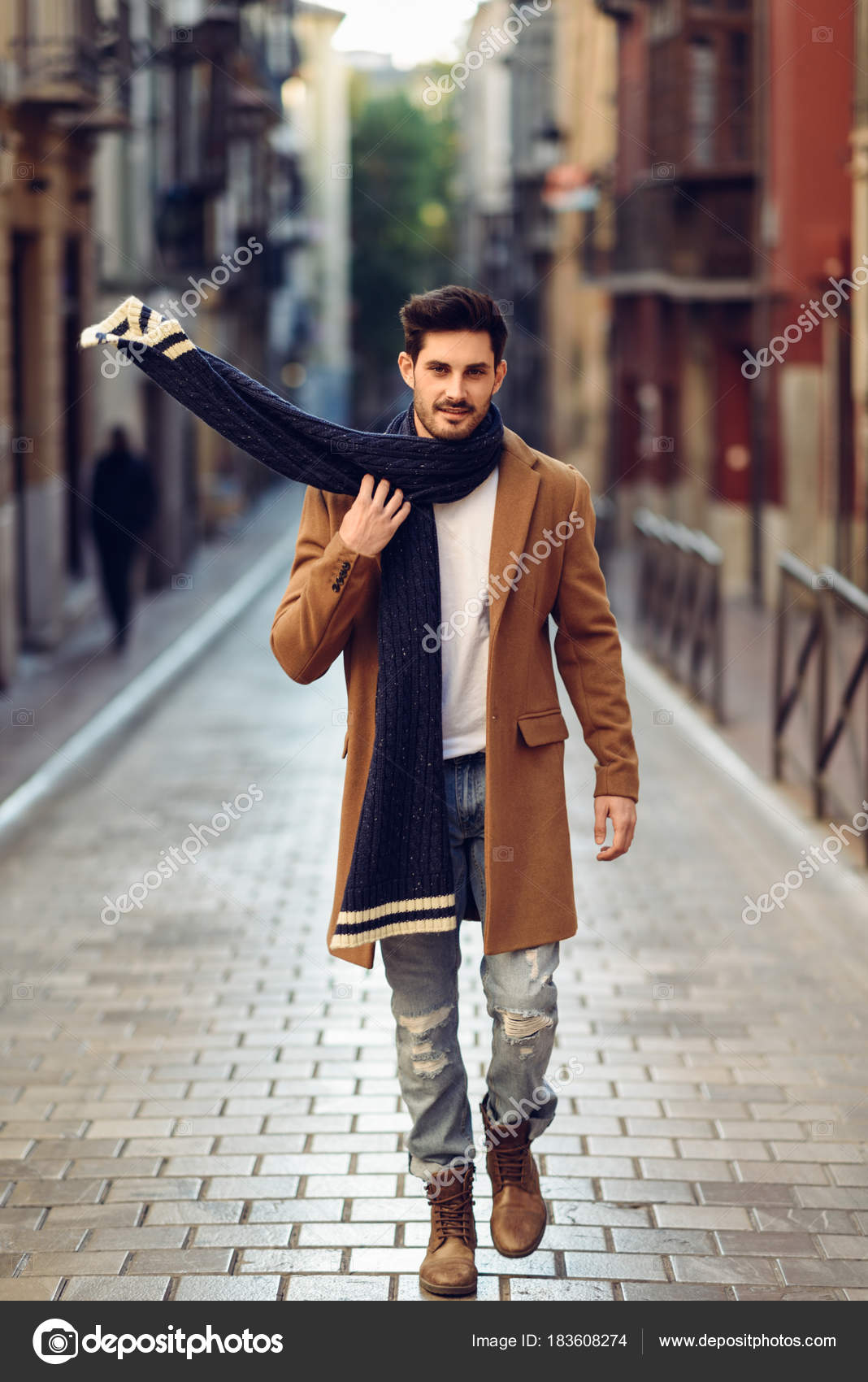 Young man wearing winter clothes in the street. Stock Photo by