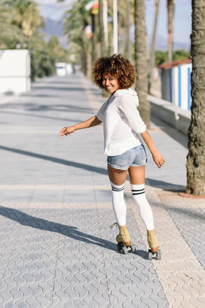 Zwarte vrouw op rolschaatsen Skaten in strand promenade wi — Stockfoto