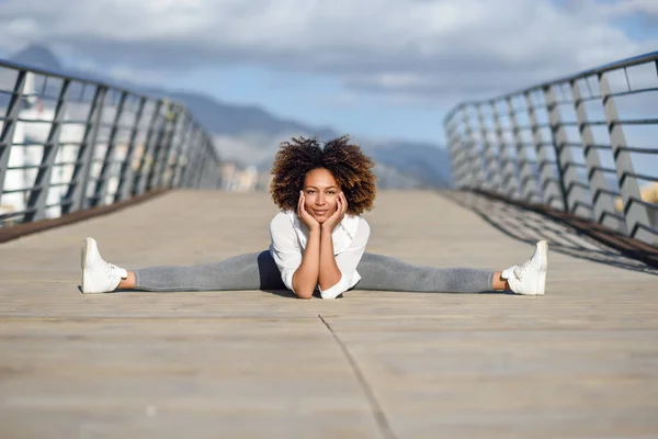 Jonge zwarte vrouw doen stretching na het uitvoeren van buitenshuis — Stockfoto