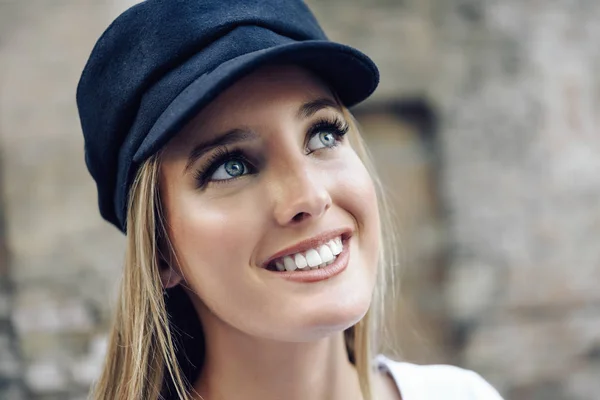 Young blonde woman wearing cap in urban background. — Stock Photo, Image