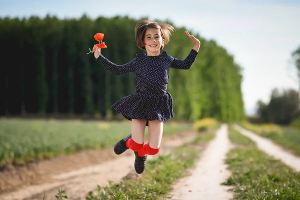 Маленькая девочка ходит по полю природы в красивом платье — стоковое фото