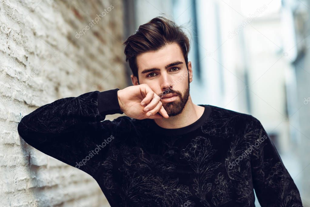 Young bearded man, model of fashion, in urban background wearing