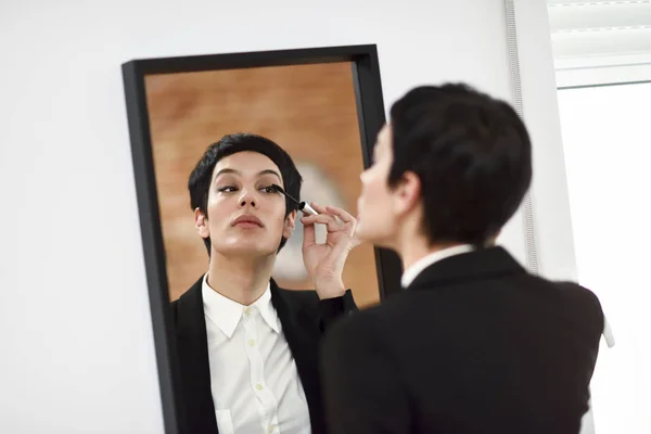 Ung kvinna med mycket kort frisyr, sätta makeup på främre — Stockfoto