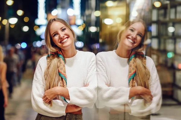 Блондинка улыбается с разряженным городским освещением ночью — стоковое фото