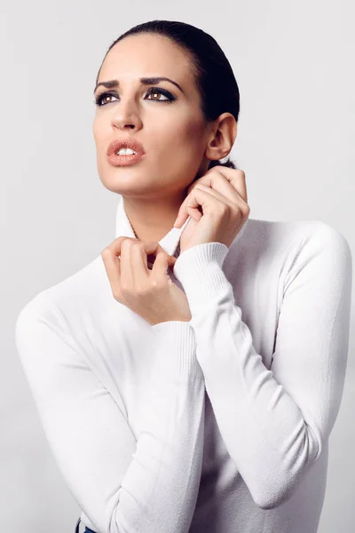 Jonge brunette vrouw dragen witte poloneck in studio schot — Stockfoto