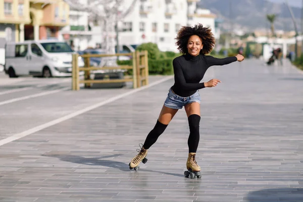 Zwarte vrouw op rolschaatsen riding buitenshuis op stedelijke street — Stockfoto