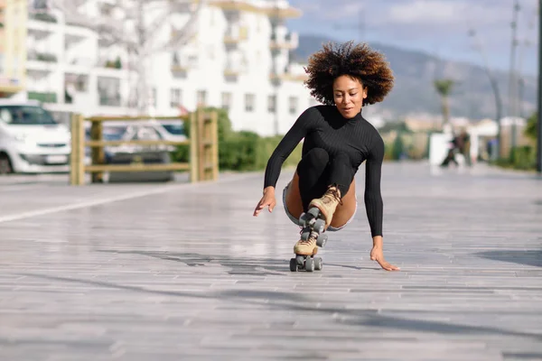 Mujer negra en patines cayendo al suelo . — Foto de Stock