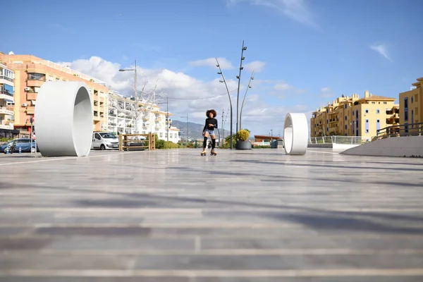 Femme noire sur patins à roulettes chevauchant à l'extérieur sur la rue urbaine — Photo