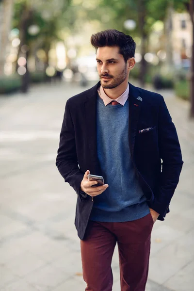 Man in de straat in formalwear met smartphone in zijn hand. — Stockfoto