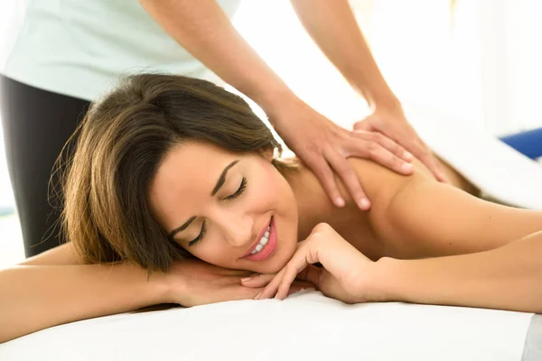 Jovem que recebe uma massagem nas costas em um centro de spa. — Fotografia de Stock