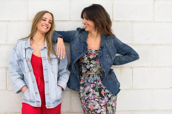 Dos mujeres jóvenes sonriendo en el fondo urbano —  Fotos de Stock
