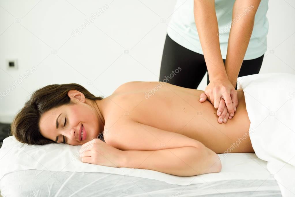 Young female receiving a relaxing back massage in a spa center. 