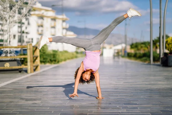 Preto ajuste mulher fazendo fitness acrobacias no urbano fundo — Fotografia de Stock