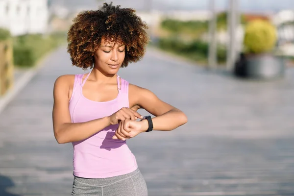 Jeune femme noire en utilisant smartwatch tactile écran — Photo