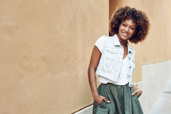 Jonge zwarte vrouw, die afro kapsel, lacht in stedelijke achtergrond — Stockfoto