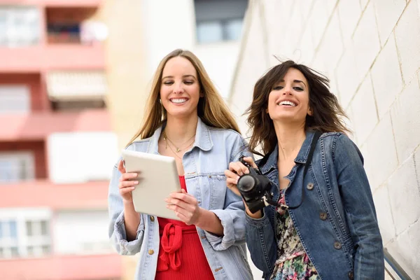 Δύο μικρά τουριστικά γυναίκες, κοιτάζοντας χάρτες με υπαίθρια ψηφιακή δισκίο — Φωτογραφία Αρχείου
