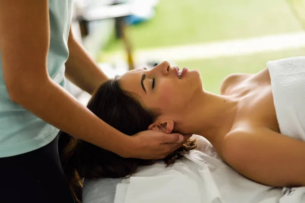 Jovem sorrindo mulher recebendo uma massagem na cabeça em um centro de spa . — Fotografia de Stock