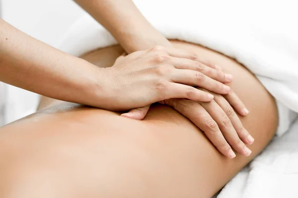Jovem que recebe uma massagem nas costas em um centro de spa. — Fotografia de Stock
