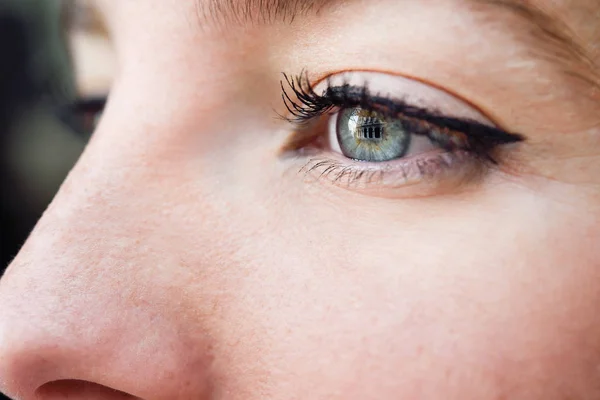 Крупный план голубого глаза молодой женщины — стоковое фото