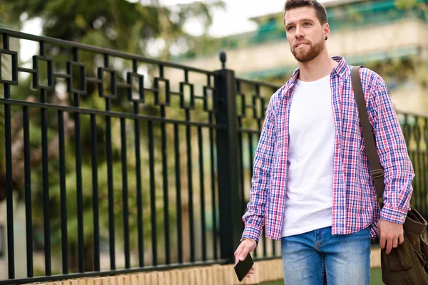 Jeune homme barbu marchant en arrière-plan urbain. Concept de style de vie — Photo