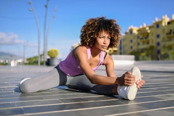 Молодая черная женщина делает растяжку после бега на открытом воздухе — стоковое фото