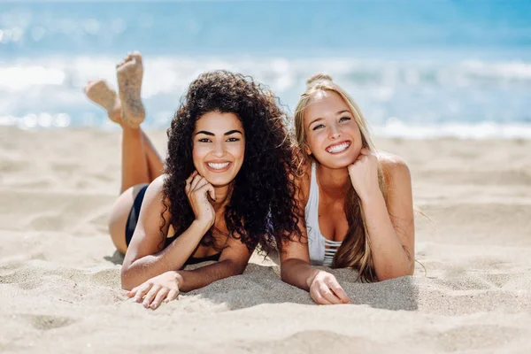 Twee jonge vrouwen met mooie lichamen in zwembroek op een tropische — Stockfoto