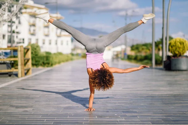 Preto ajuste mulher fazendo fitness acrobacias no urbano fundo — Fotografia de Stock
