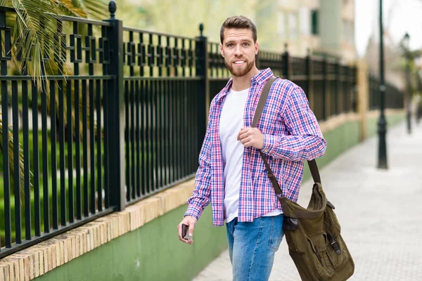 Jeune homme barbu marchant en arrière-plan urbain. Concept de style de vie — Photo