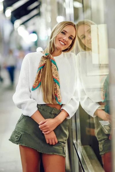 Blonde girl smiling with defocused urban city lights at night — Stock Photo, Image