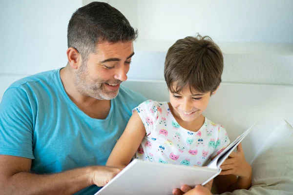 Père d'âge moyen avec sa fille de huit ans en utilisant une tablette numérique dans la chambre . — Photo