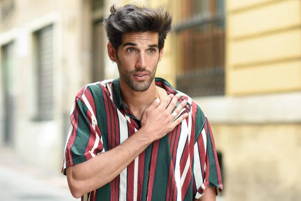 Attraente giovane uomo con i capelli scuri e acconciatura moderna che indossa abiti casual all'aperto — Foto Stock