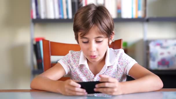 Menina feliz jogando um jogo usando telefone inteligente . — Vídeo de Stock