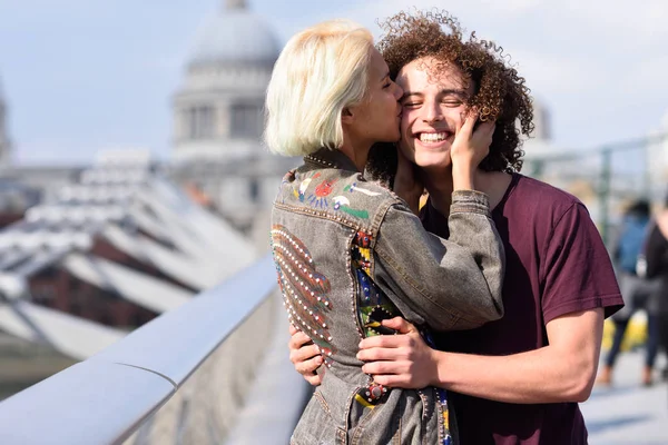 Glückliches Paar, das sich an Millennium Bridge, Themse, London umarmt. — Stockfoto