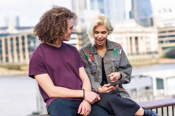 Щаслива пара розмовляє сидячи біля річки Темзи. — стокове фото