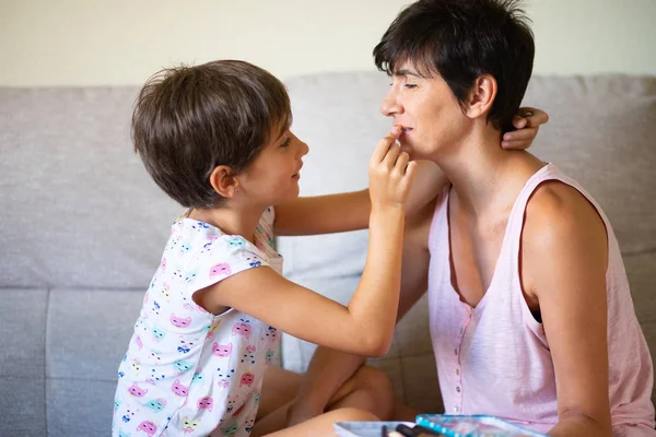 Мама и ее маленькая дочь делают макияж друг для друга — стоковое фото