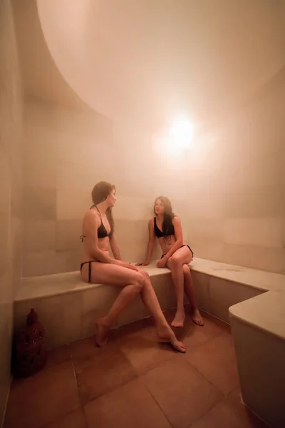Dos mujeres jóvenes disfrutando de baño turco o hammam — Foto de Stock