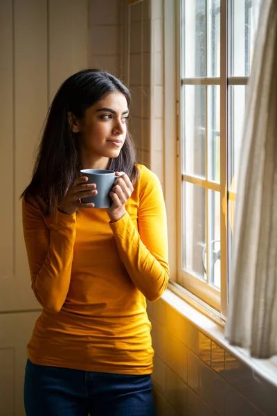 Perserin trinkt Kaffee, während sie aus dem Fenster schaut — Stockfoto