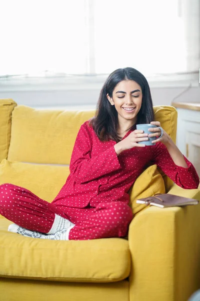 Evde çay içip kitap okuyan bir kadın var. — Stok fotoğraf