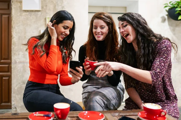 Groep van drie gelukkige vrienden die koffie drinken in een café bar. — Stockfoto